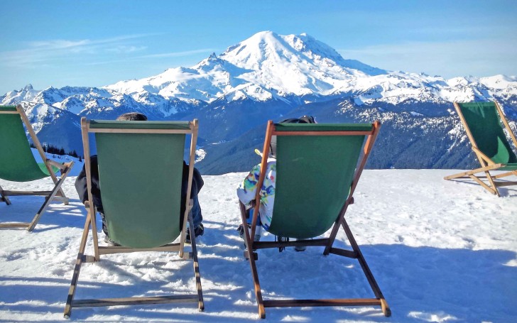 Skiers take in the view of Mount Rainier from the Summit House area of Crystal Mountain. Credit: John Nelson
